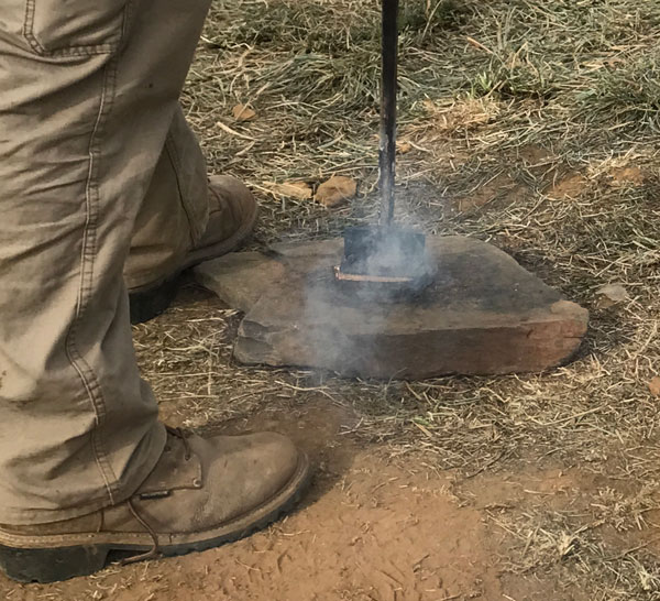 A worker burning into the piece of the tree