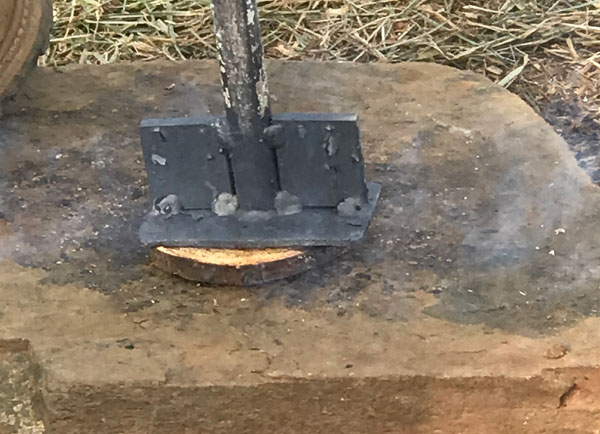 A worker burning into the piece of the tree