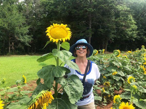 Karen Duquette by a tall sunflower