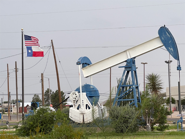 USA flag, the Texas flag, and an oil well at the Visitor Center