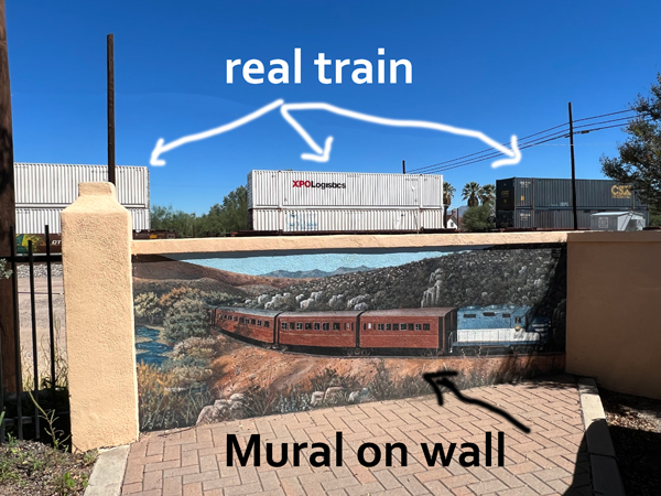 real train above a train mural