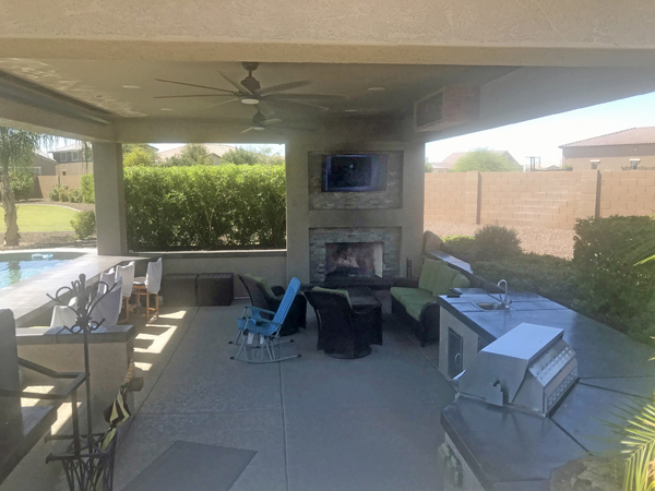 nice enclosed patio room with TV, fireplace, and a kitchen