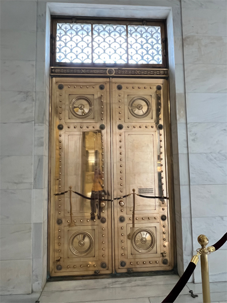 Karen Duquette's reflection in the bronze doors