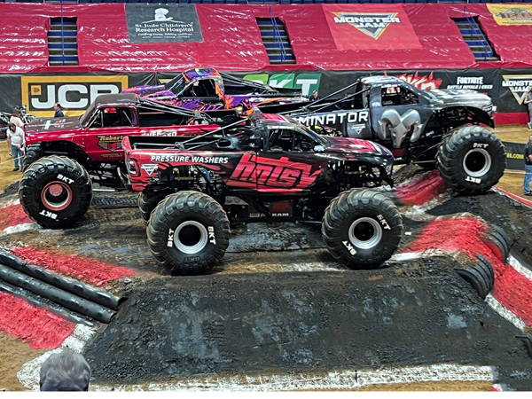 4 monster trucks on the mound in the pits