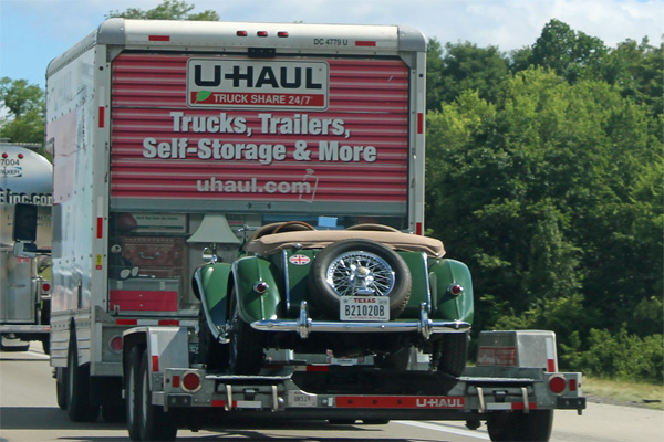 U-Haul truck towing a cool convertible car