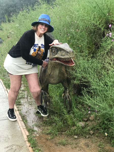 Karen Duquette petting a dinosaur