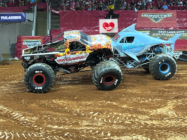 two monster trucks kissing