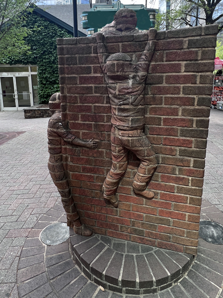 Boys climbing a brick wall