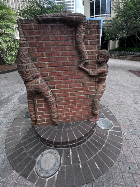 Boys climbing a brick wall