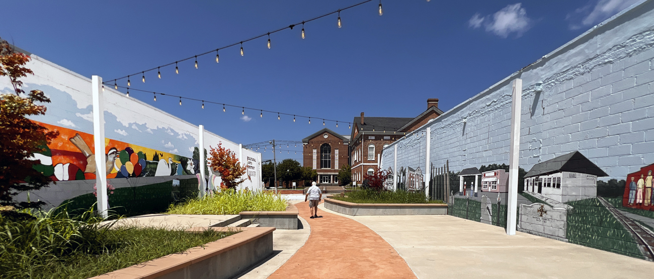 Lee Duquette walking between the two murals