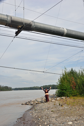 Karen Duquette standing under the Alaska Pipeline