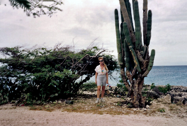 Karen Duquette by a Divi Divi tree and a tall cacti