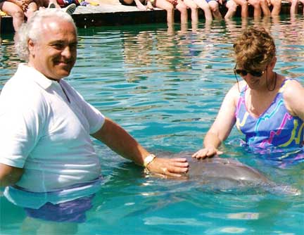 Lee Duquette touching a dolphin