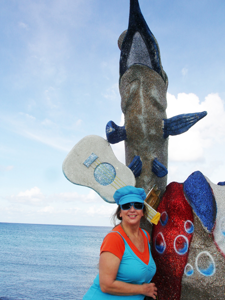 Karen Duquette and a beautiful dolphin statue by the sea