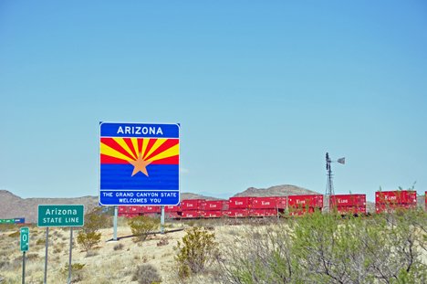 Arizona state line sign, welcome to Arizona sign, and a train