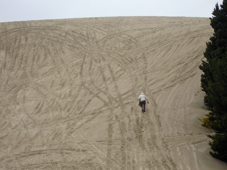 Lee walking up the steep sand dune
